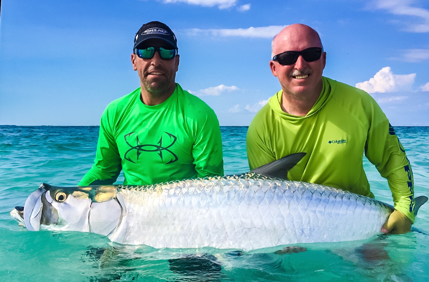 a fishing guide and client holdinga large tarpon caught in bradenton