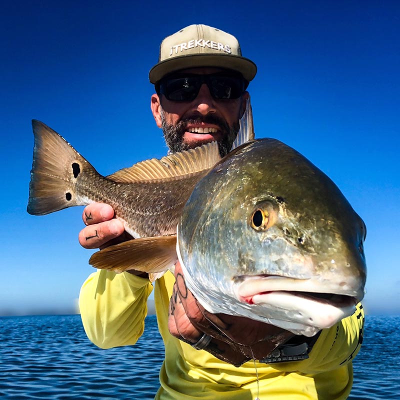 a picture of Capt. Nate holding a large redfish he caught in Sarasota in the waters of Tampa Bay.