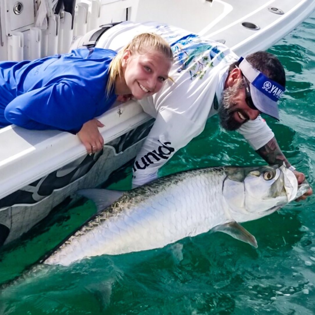 a picture of a fisherman and captain nate showing a huge tarpon they caught in anna maria island Florida