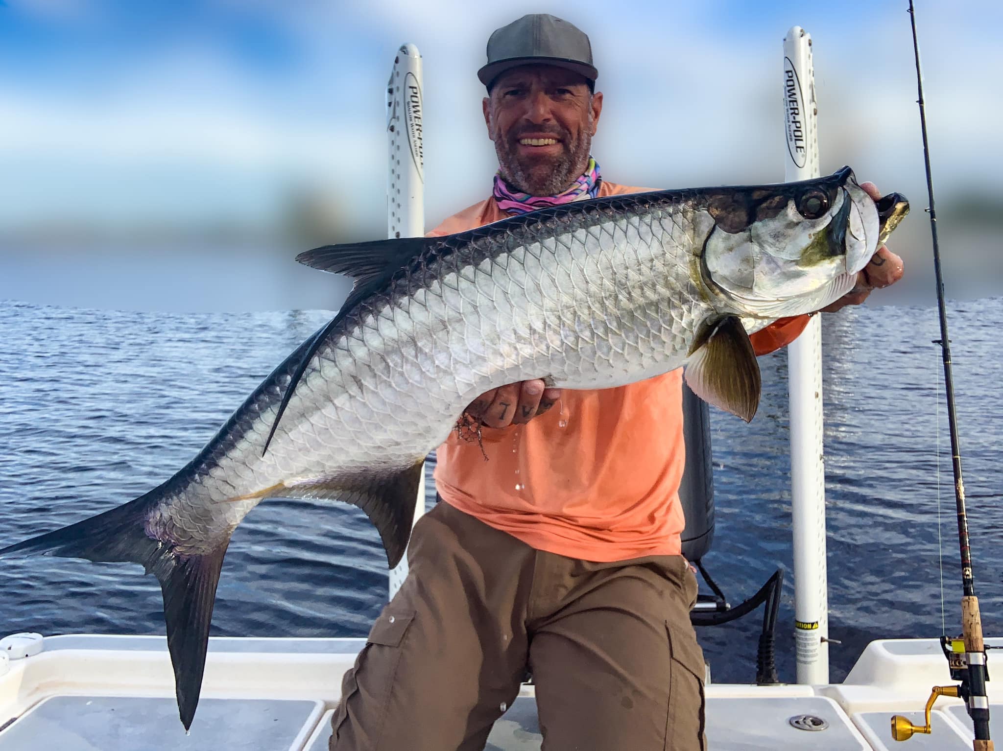 a picture of Captain Nate holding a tarpon caught off holmes beach