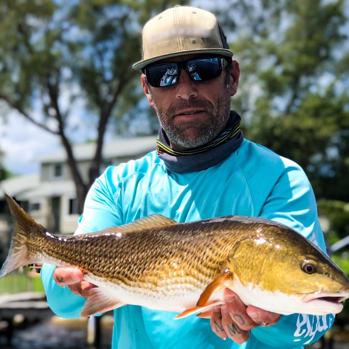 a picture of a fisherman holding a redfish