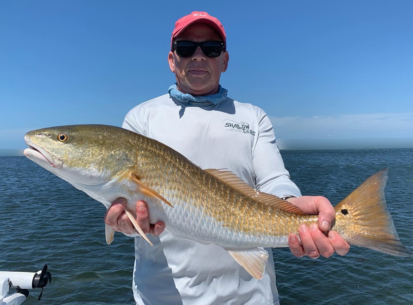 a fisherman who caught a large redfish on a springtime Bradenton fishing charter